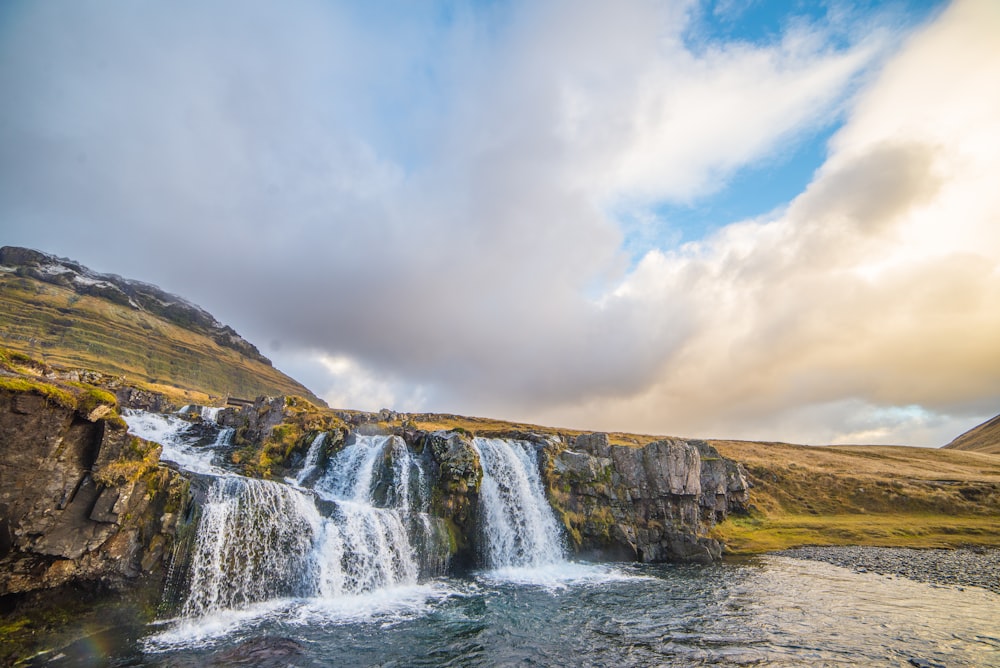 waterfalls under blue clouds during daytime