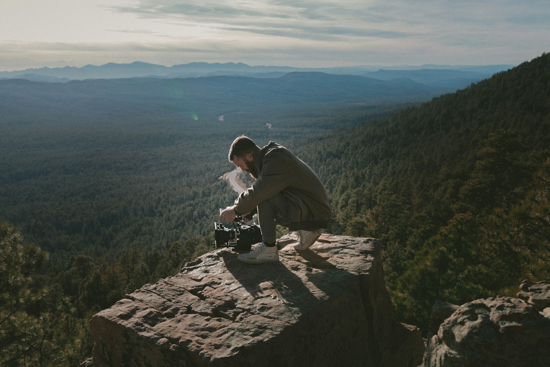 A serene landscape featuring a filmmaker capturing the essence of nature with a camera.