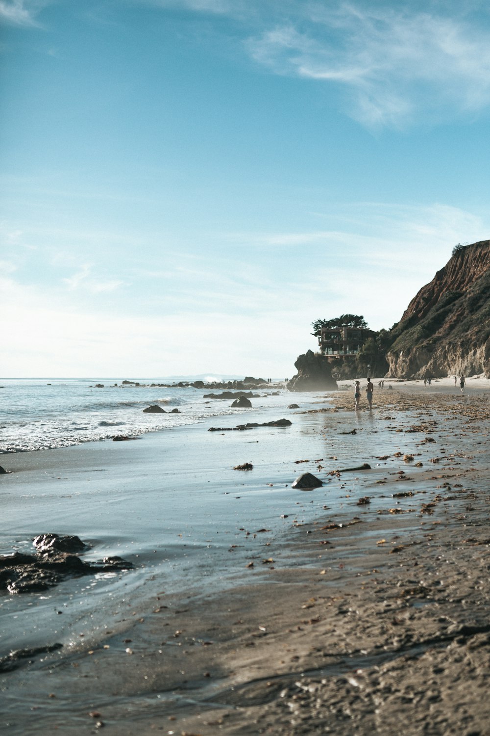 few people near seashore viewing sea under blue and white skies