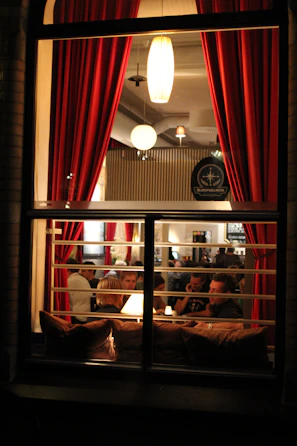 Guests enjoying a cozy evening meal surrounded by deep red and orange decor.