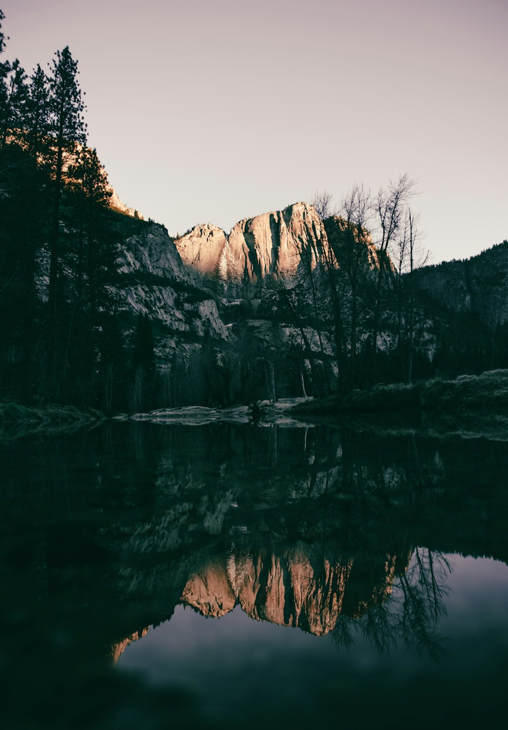 rock mountain across body of water