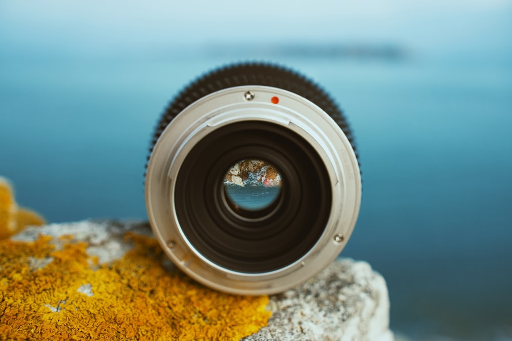 round black and grey camera lens on rock