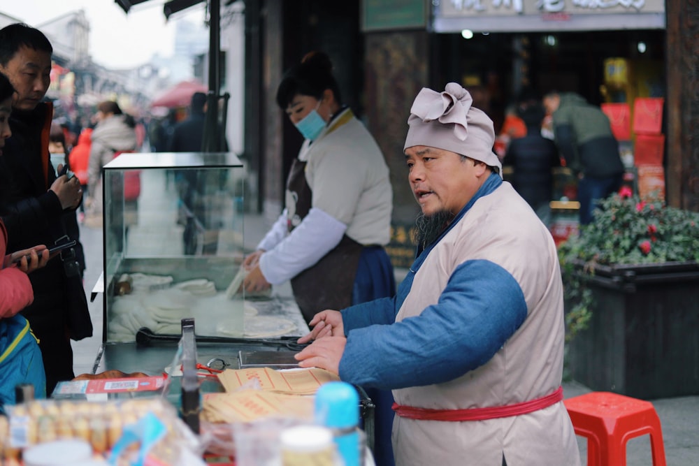 man serving food near red stool