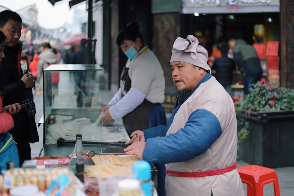Hombre sirviendo comida cerca de un taburete rojo