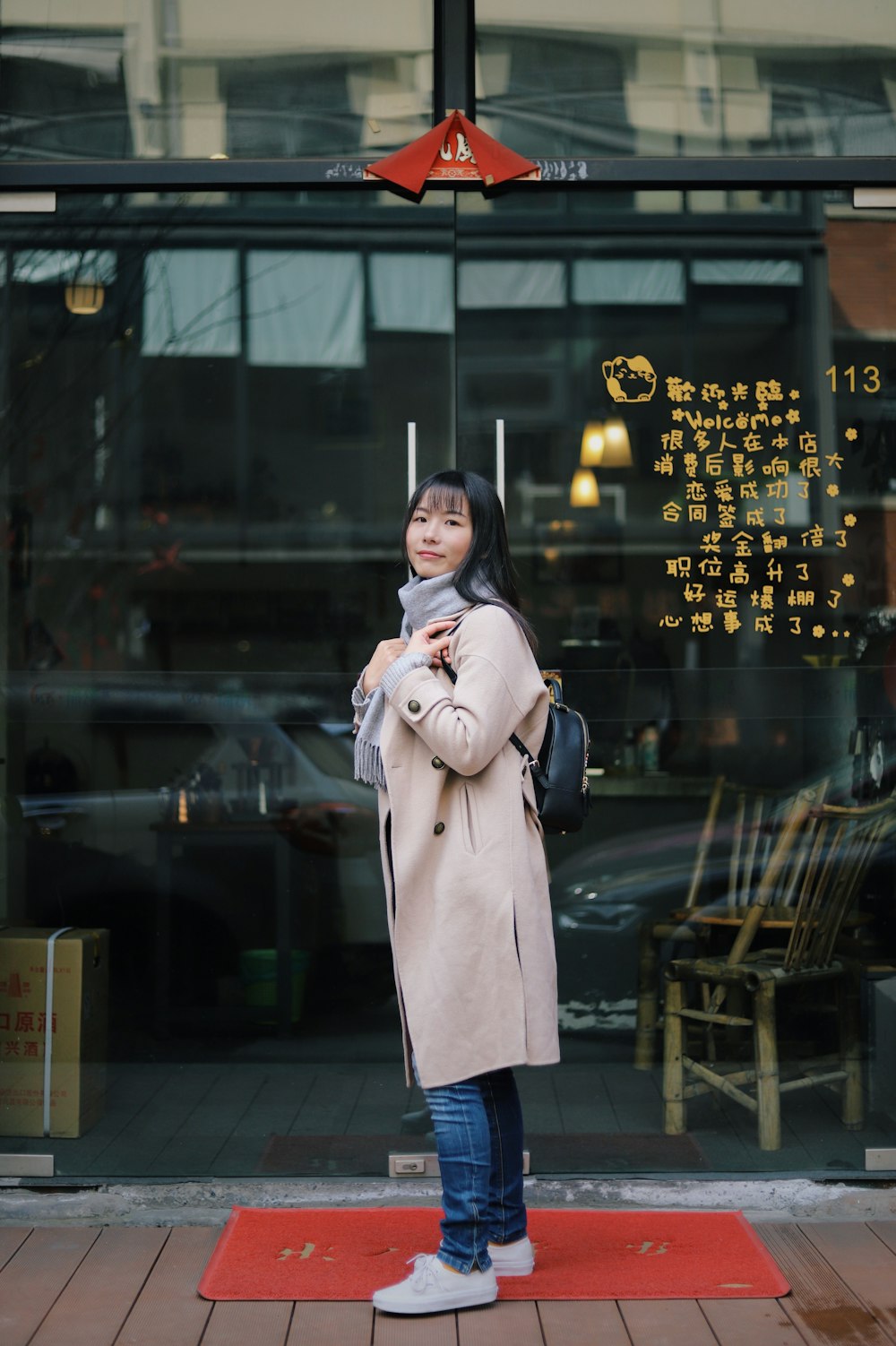 woman wearing brown coat standing on red place mat during daytime