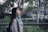 woman in gray scarf and coat standing near bridge
