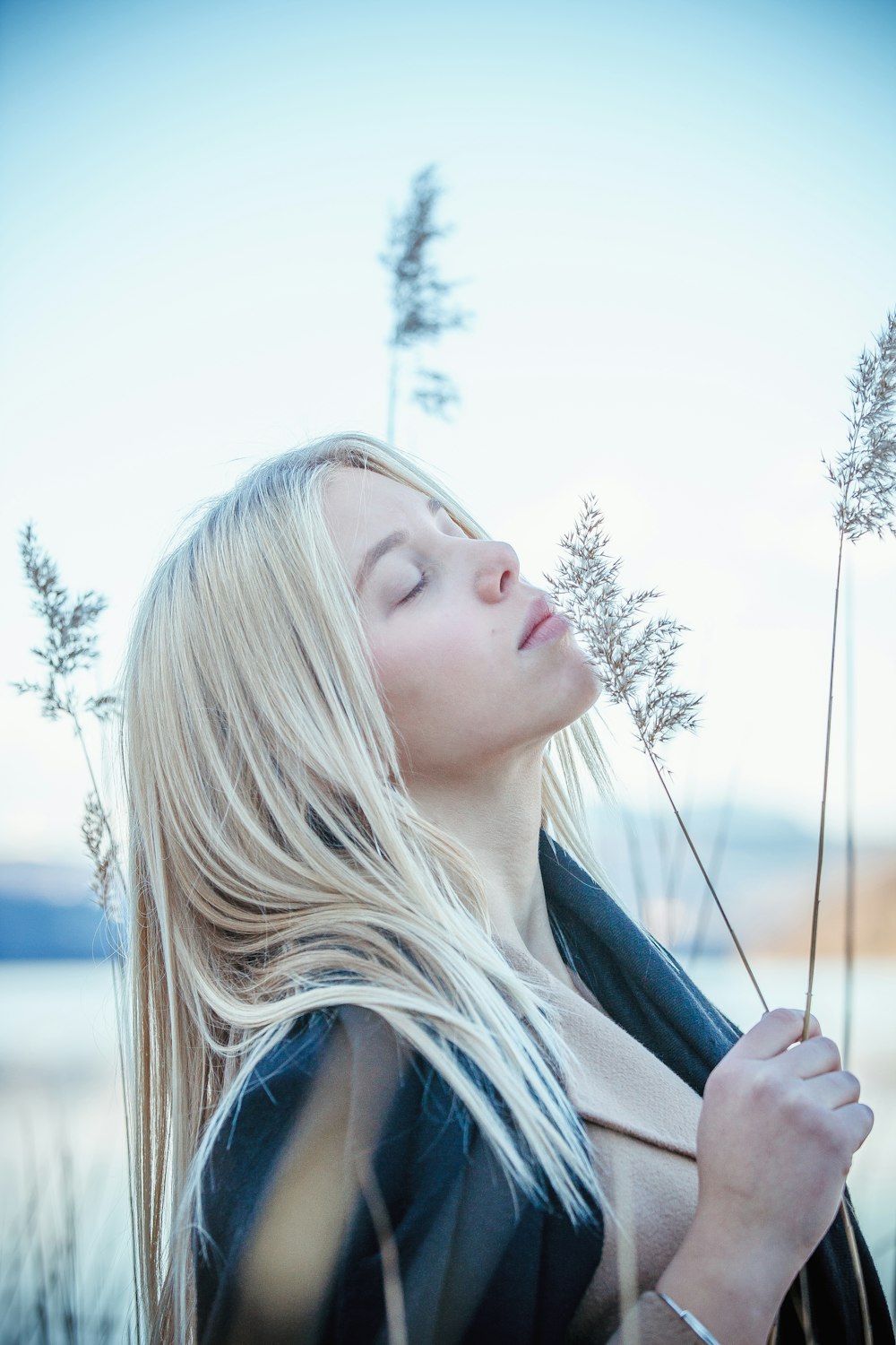 selective focus photo of woman holding green plant during daytime