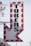 A vintage-style illuminated sign with the word 'TOKENS' in bold black letters. The letters are arranged vertically on a white background, bordered with red, with round lights outlining the edges of the sign. The bottom of the sign forms an arrow pointing downward.