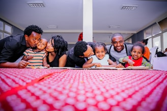 A warm family gathering around a table, smiling and sharing messages on their phones