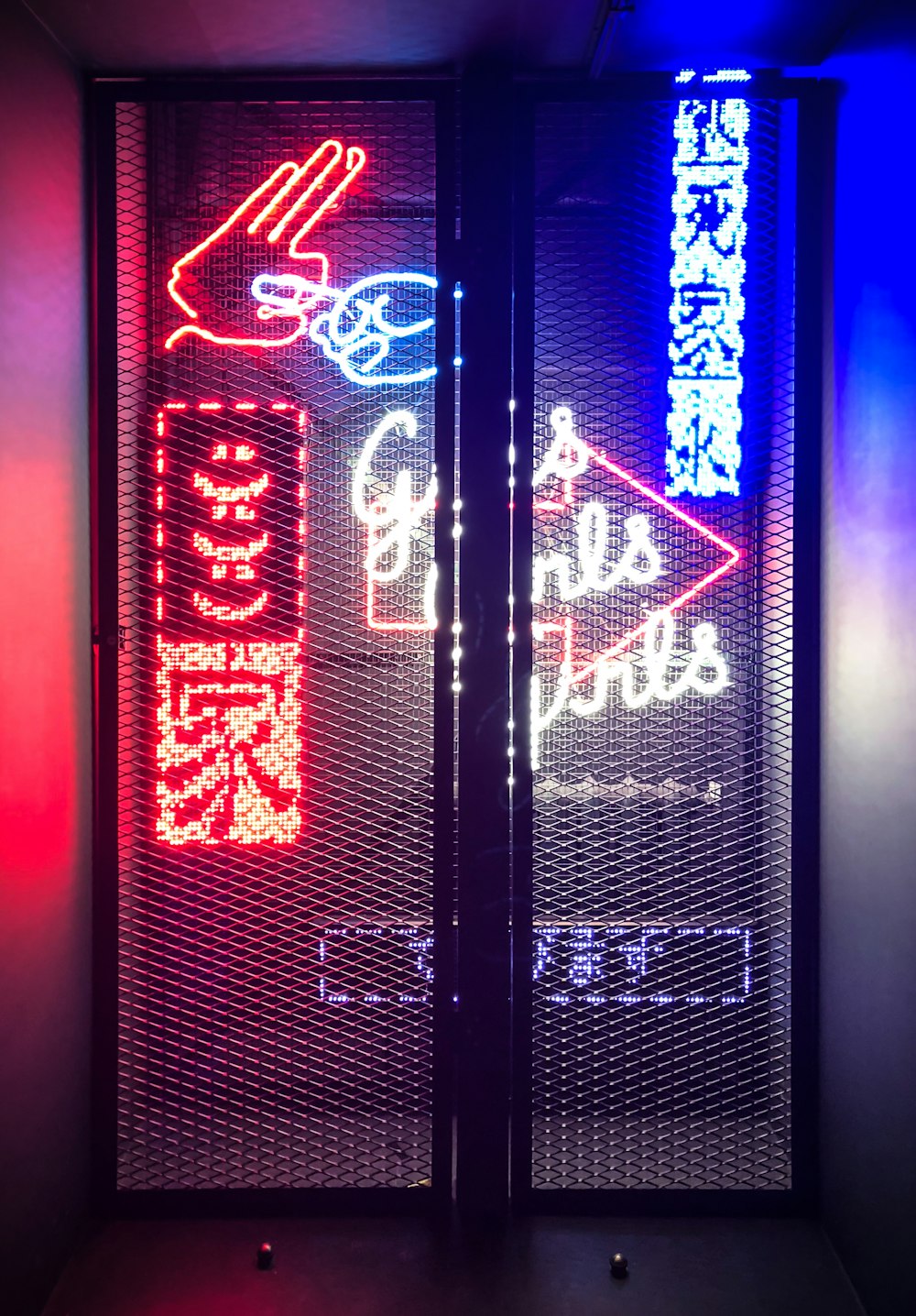 black metal mesh gate in front of LED signages