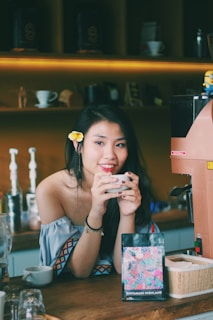 A smiling customer holding a unique piece of merchandise in a cozy shop setting.