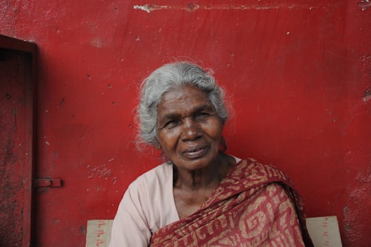 woman sitting near red painted wall in Bengaluru India