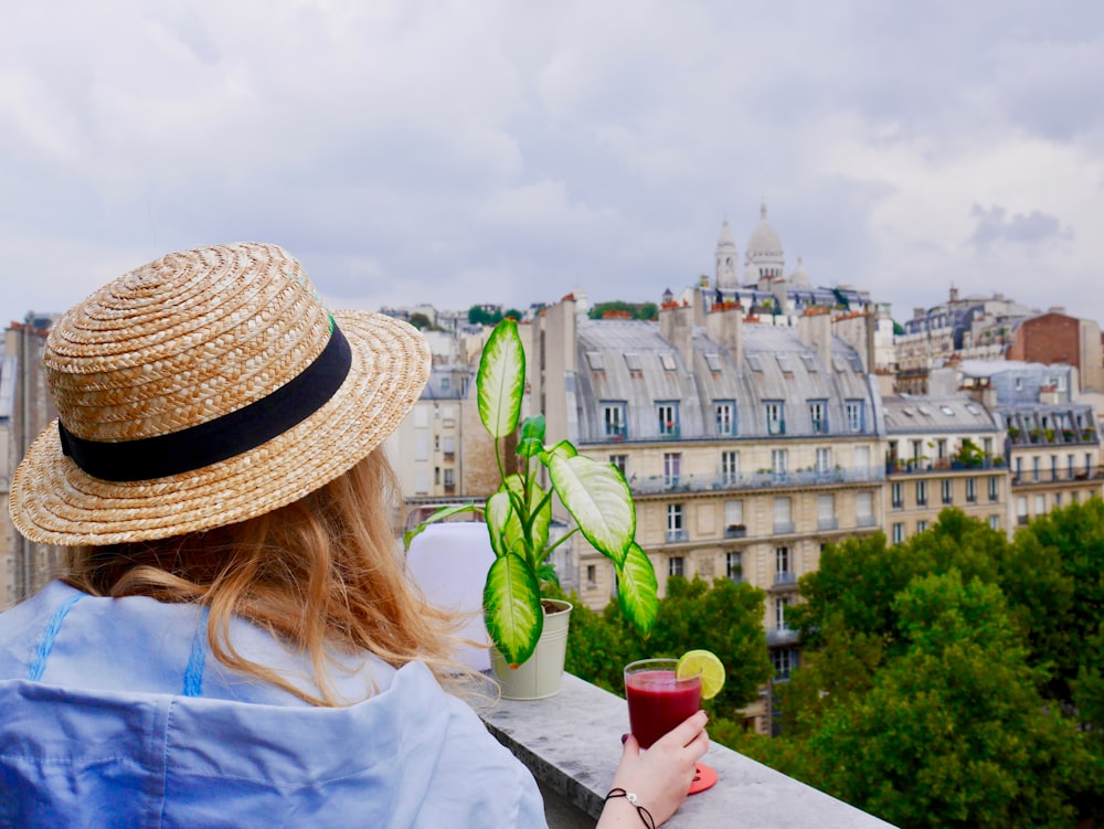Mujer sosteniendo un vaso con jugo rojo mientras está en la terraza