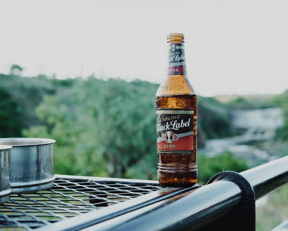 brown glass bottle on grey metal rail