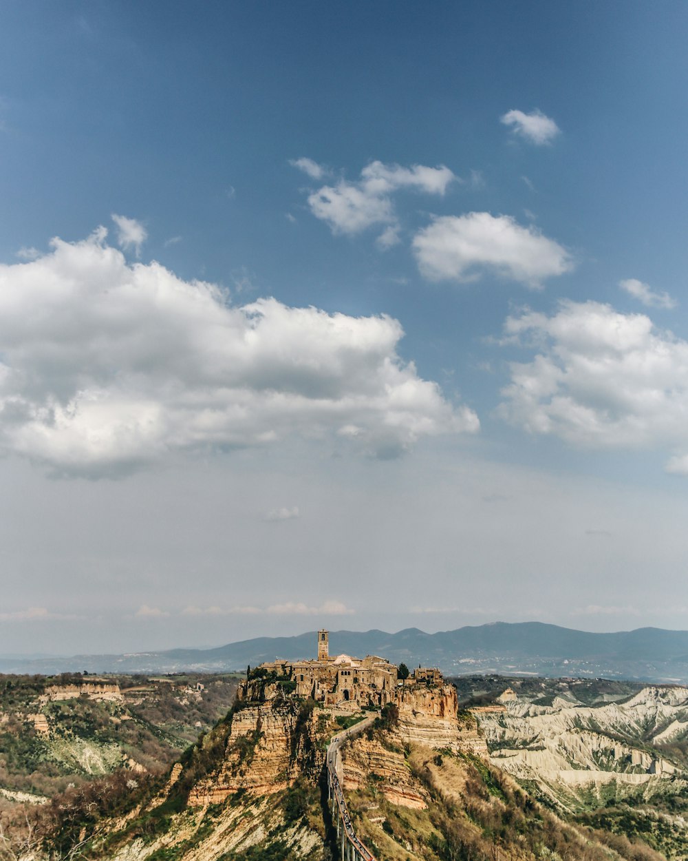 brown rock formation under white and blue sky