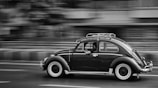 grayscale photo of moving beetle car