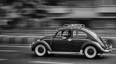 grayscale photo of moving beetle car