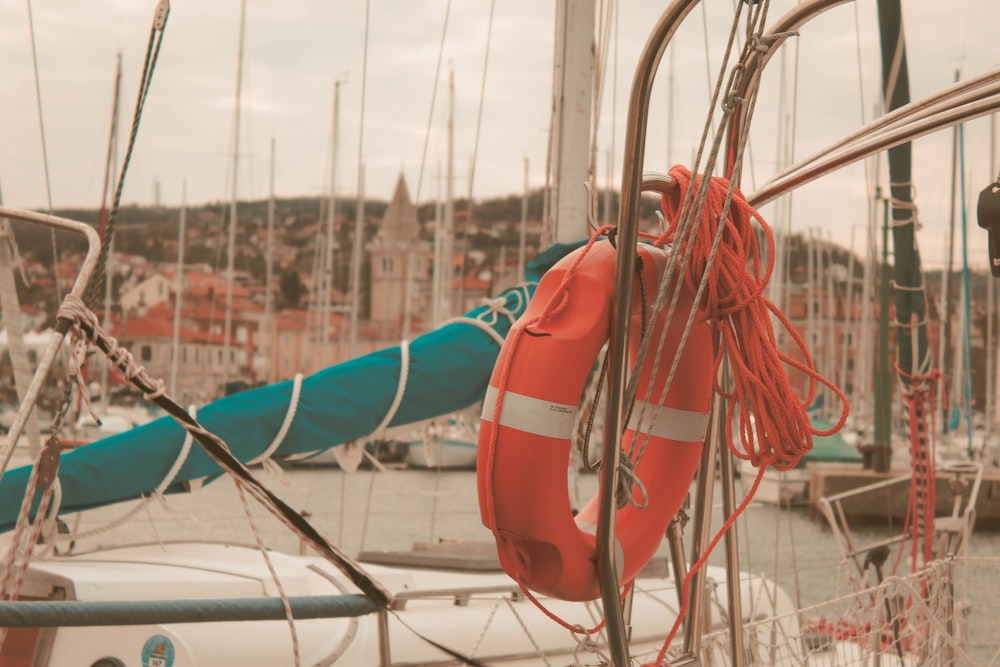 orange and white inflatable float ring tied to boat during daytie