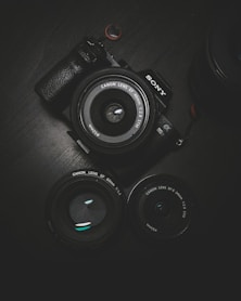 flat lay photography of black Sony DSLR camera on black surface