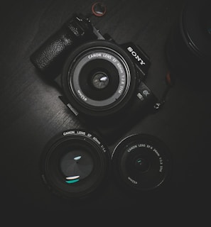 flat lay photography of black Sony DSLR camera on black surface