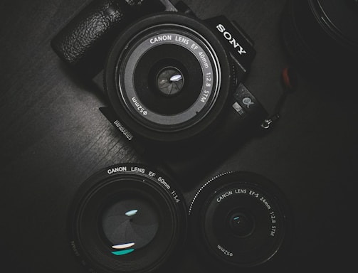 flat lay photography of black Sony DSLR camera on black surface