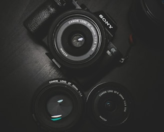 flat lay photography of black Sony DSLR camera on black surface