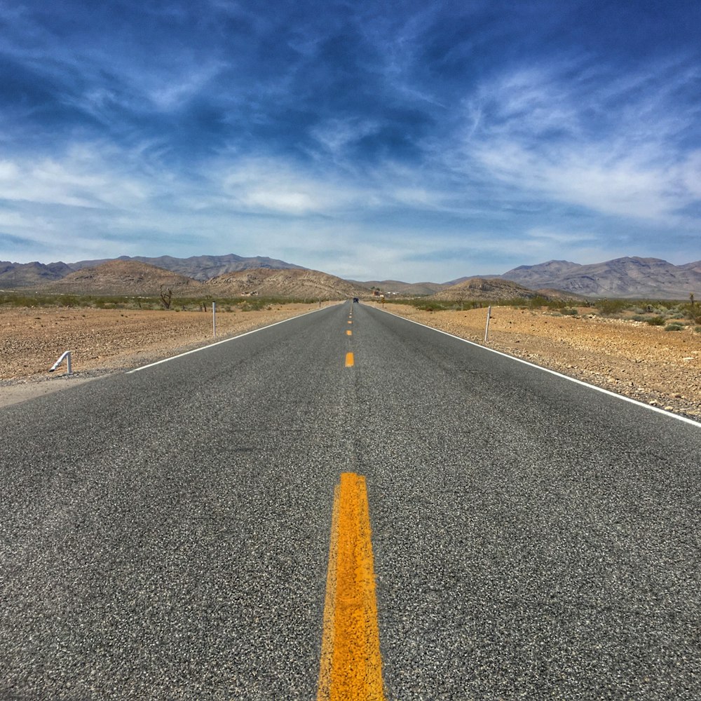 concrete road between green grass