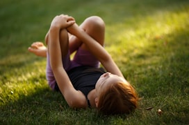 girl lying on green grass