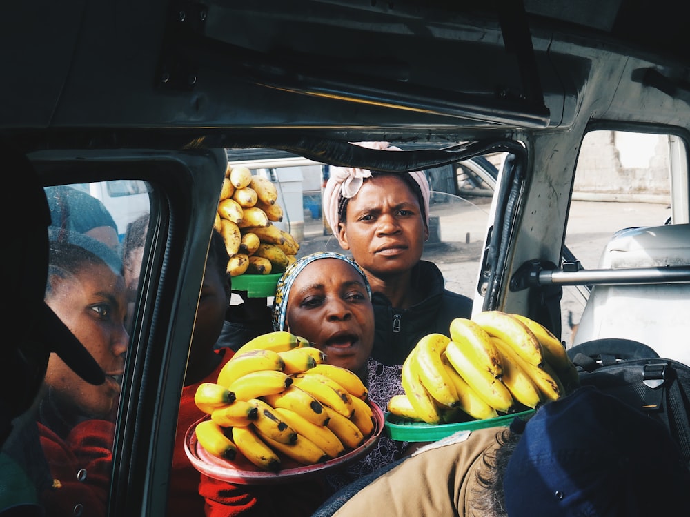 Person, die in der Nähe des Fahrzeugs steht und Bananenfrüchte hält