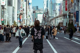 A person attentively looking around while walking through a busy city street.