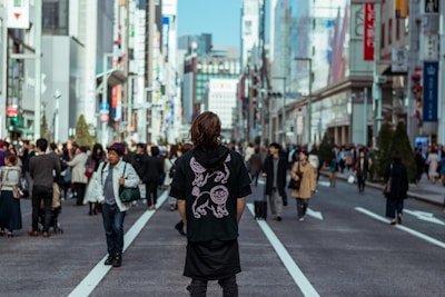 A person attentively looking around while walking through a busy city street.