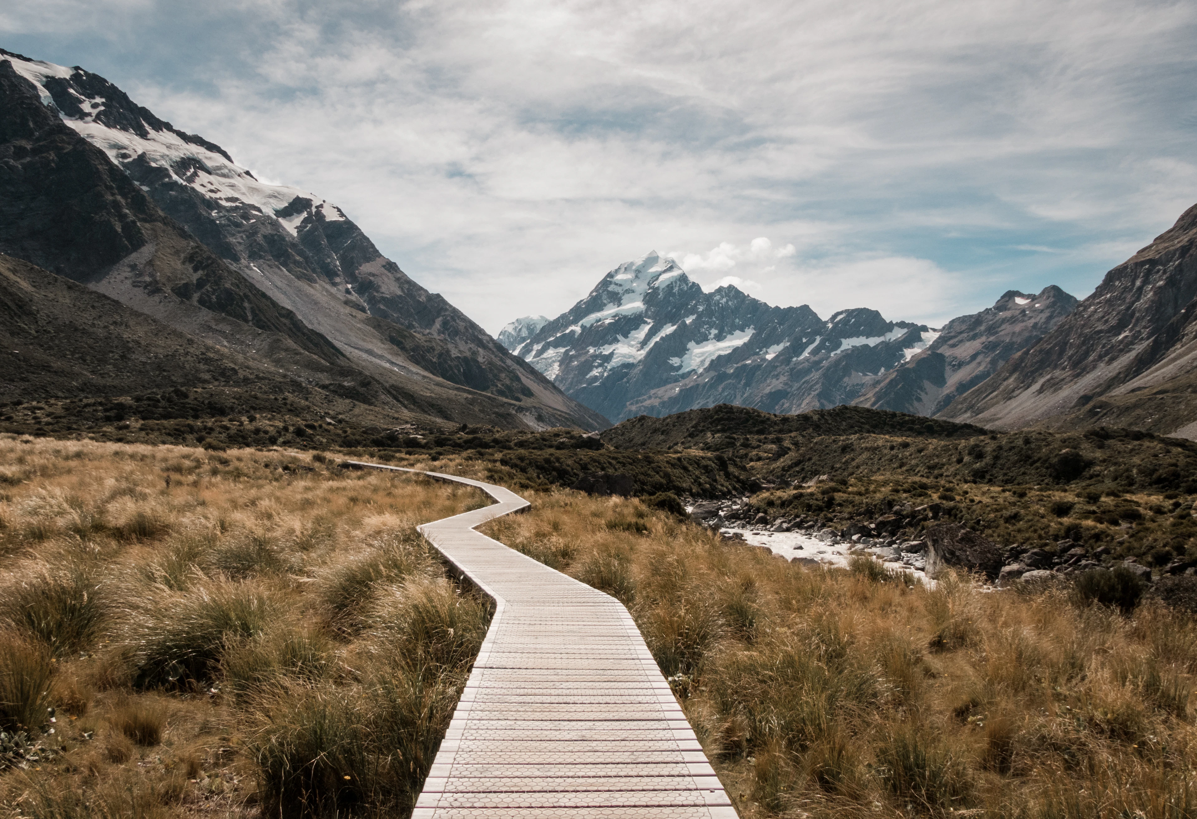 The boardwalk of the Hooker Valley Track leading towards snow-capped Aoraki / Mount Cook