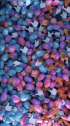 A dense pile of colorful 3D icons featuring popular social media logos such as Instagram, Twitter, and Facebook. The icons are intermingled and scattered across the frame, representing social media interaction symbols like hearts, thumbs-up, and upvotes.