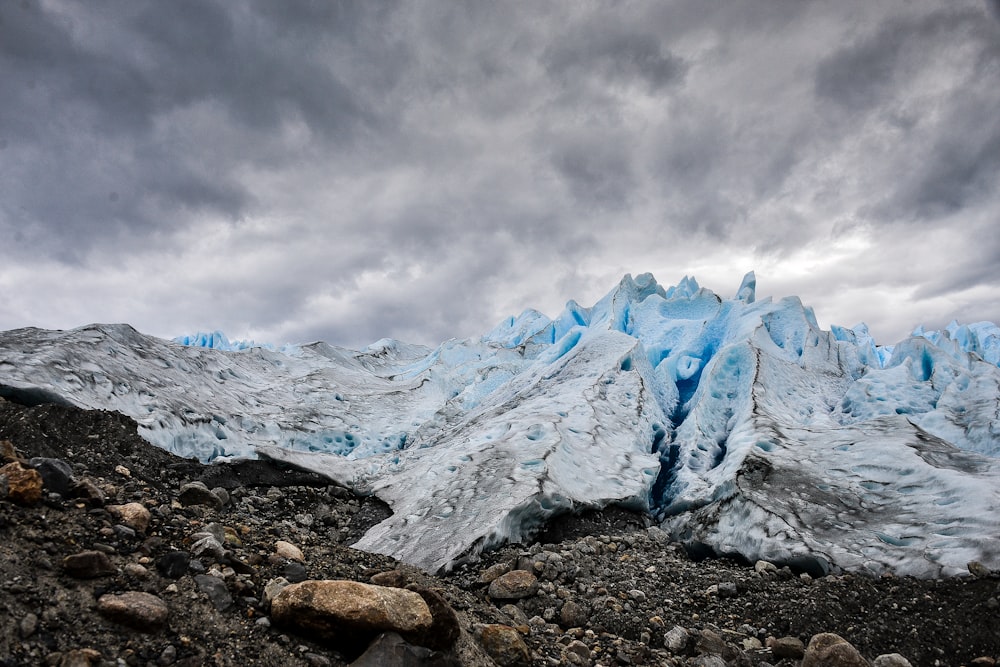 灰色の曇り空の下に氷に覆われた山