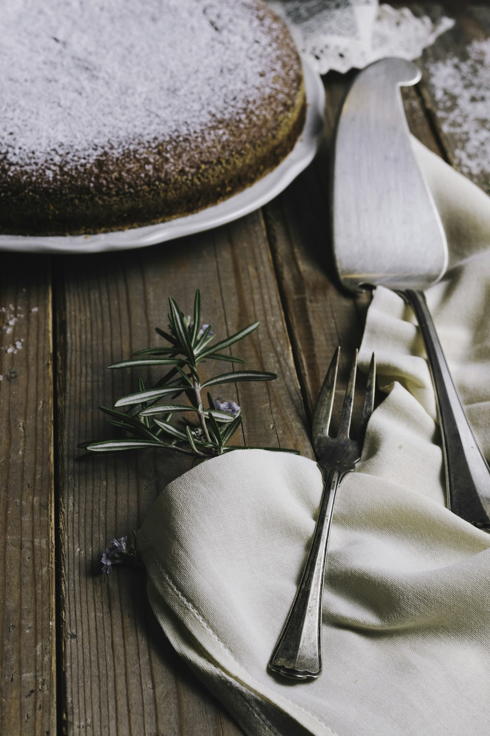 silver fork and silver pie server beside round white plate