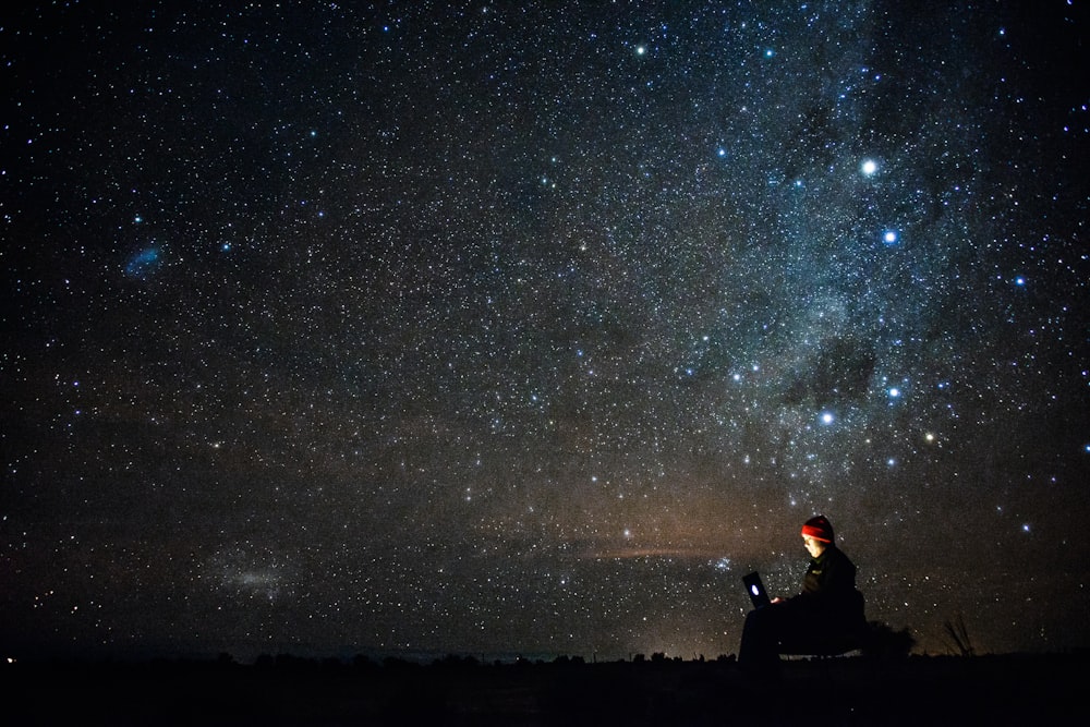 Person using a computer under a starry night