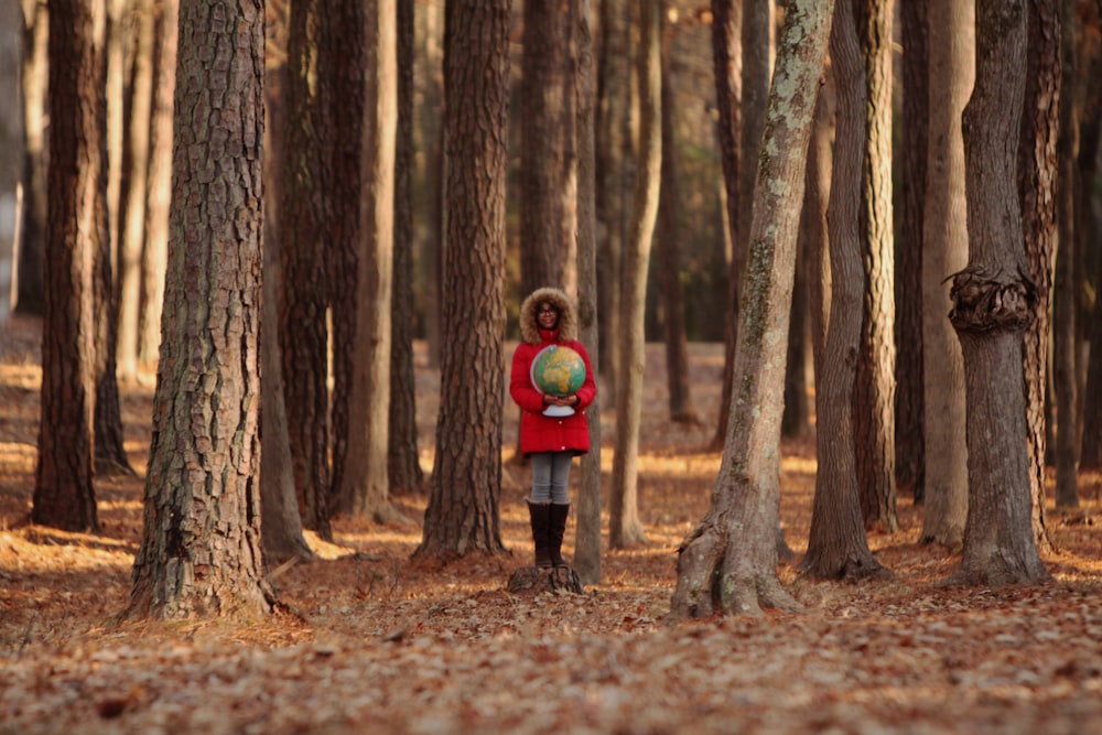 지도의 가늠자를 들고 있는 소녀는 나무에 의해 포위되어 있다