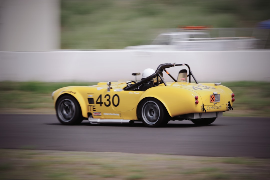man riding yellow racing car