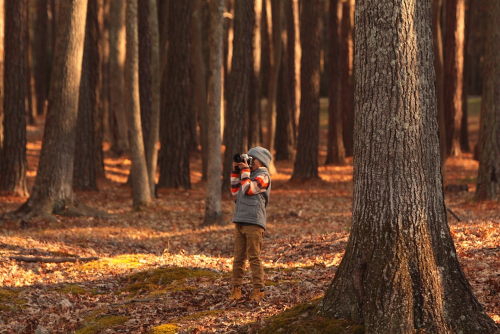 person holding camera in forest