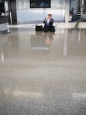 A frustrated traveler speaking on the phone in a poorly maintained hotel lobby.