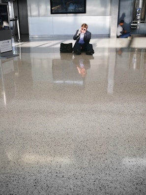 A frustrated traveler speaking on the phone in a poorly maintained hotel lobby.