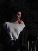 Sophisticated plus size woman in a soft off-white sweater posing outdoors with gentle sunlight
