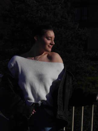Sophisticated plus size woman in a soft off-white sweater posing outdoors with gentle sunlight