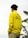 A person is wearing a bright yellow jacket with 'Erigo Beach Club' printed on the back. In the background, there are leaves, possibly from banana trees, against an overcast sky.