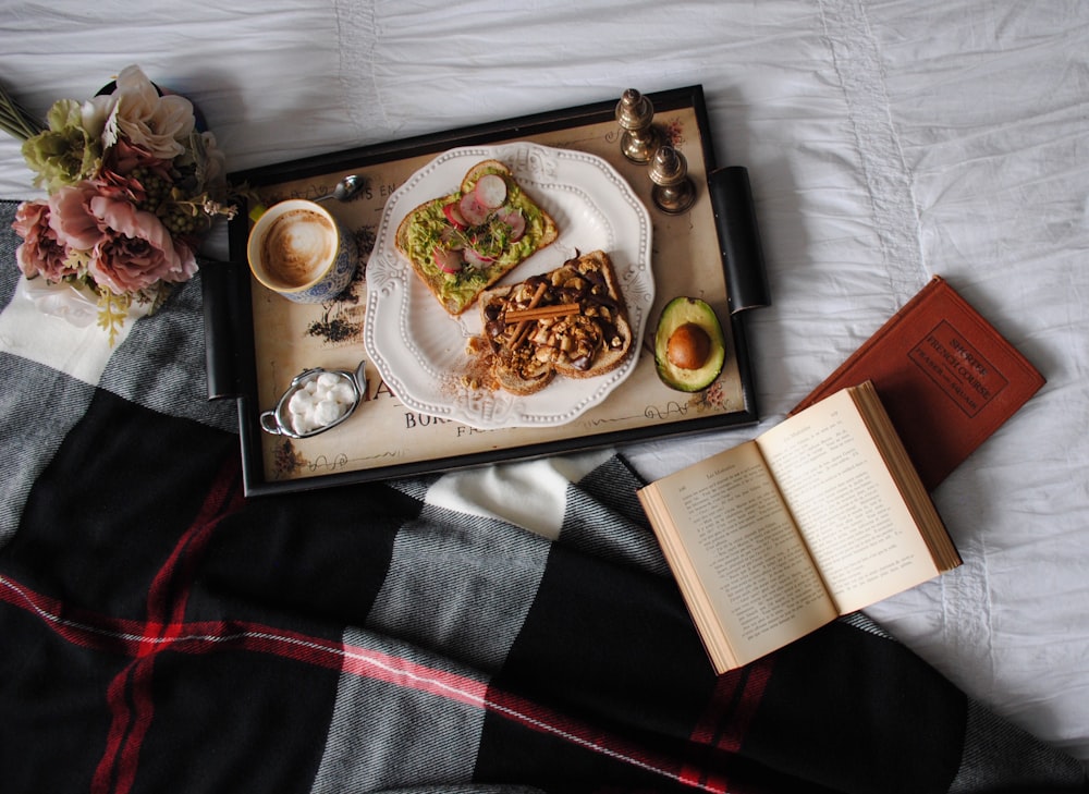 Flat-Lay-Fotografie von Speisen, die auf einem Teller auf einem schwarzen Holztablett serviert werden