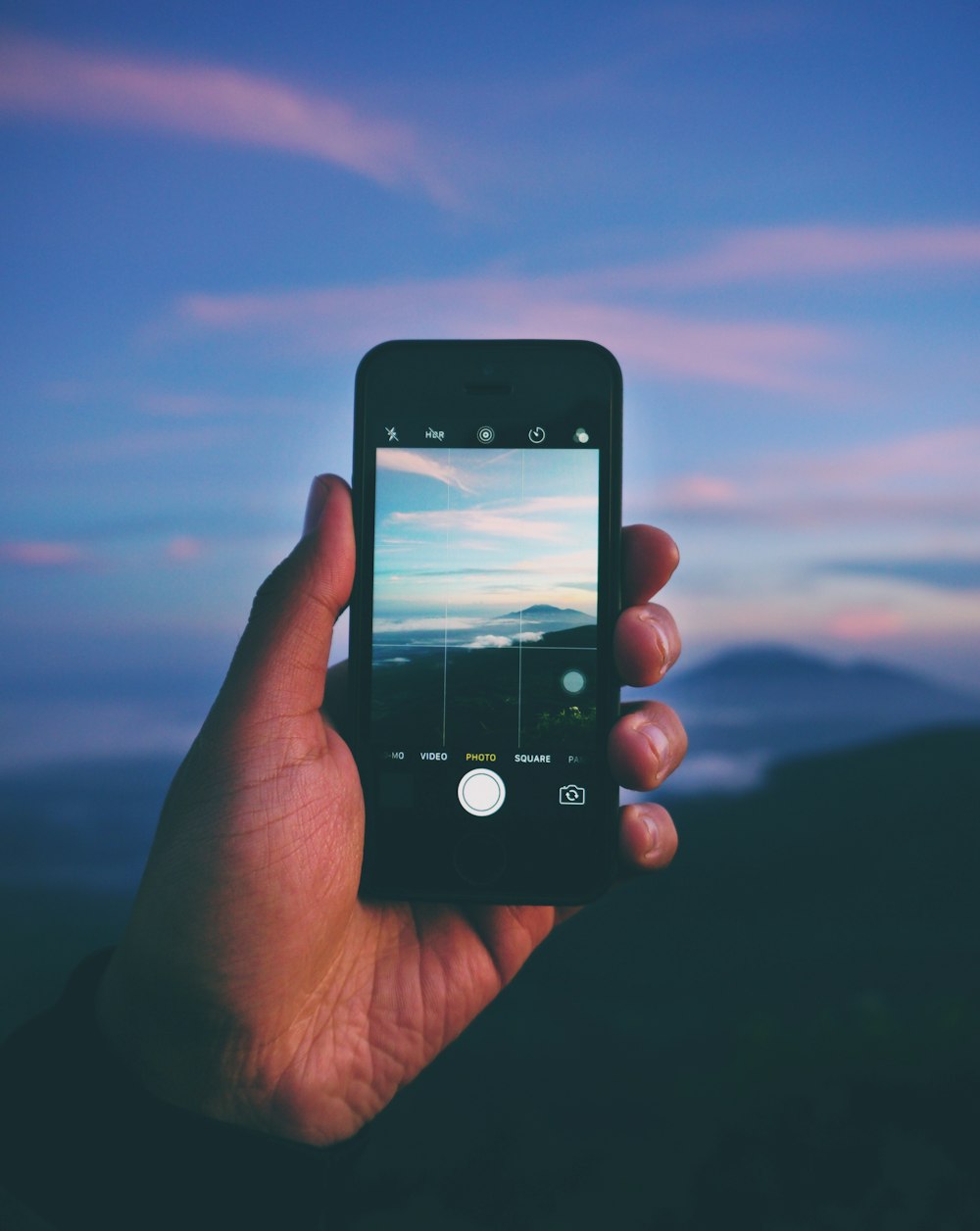 person taking photo of mountain