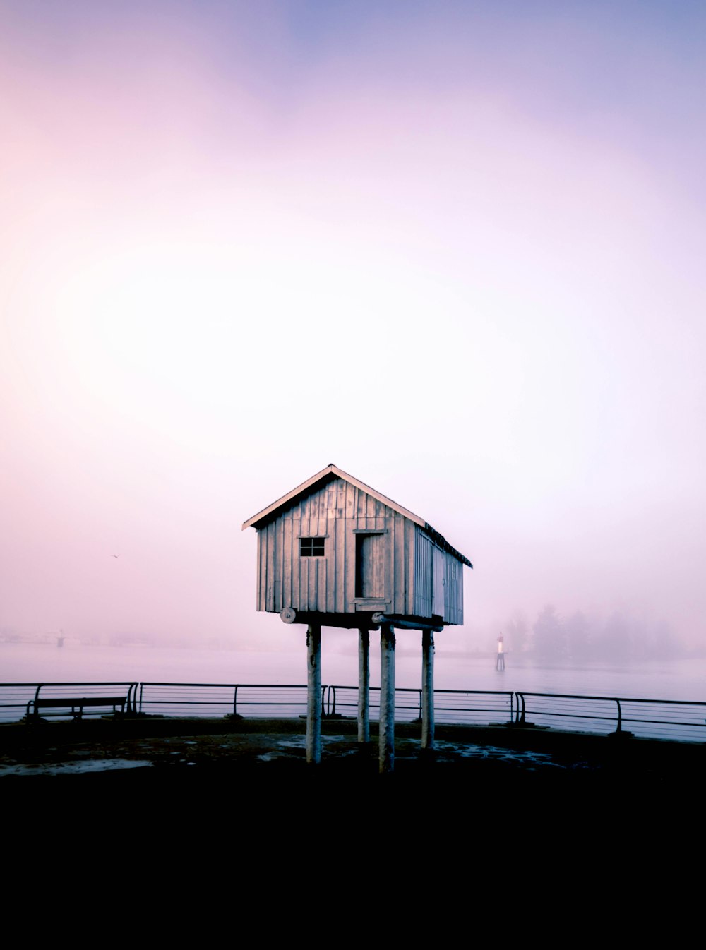 gray wooden storage shed under gray sky