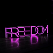 purple Freedom lighted freestanding letters on brown surface