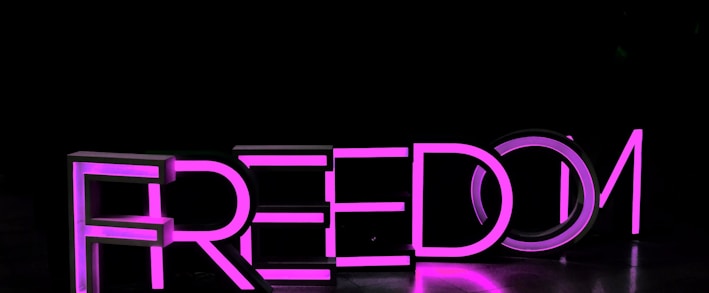 purple Freedom lighted freestanding letters on brown surface