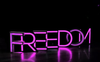 purple Freedom lighted freestanding letters on brown surface